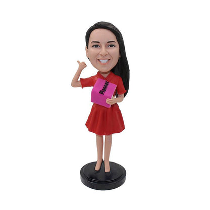 Op maat gemaakt bobbleheadmeisje dat een boekenpop vasthoudt